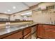 Close up of basement bar with wood cabinets, countertop, shelves, mini-fridge and glassware at 215 Sunland St, Louisville, CO 80027