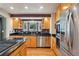 Well-lit kitchen featuring stainless steel appliances, wooden cabinets, granite countertops and a window overlooking the yard at 215 Sunland St, Louisville, CO 80027
