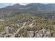 Extensive aerial view of a home situated in a lush forest with mountains in the distance at 31911 Warrens Rd, Golden, CO 80403
