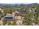 Gorgeous aerial view of a wood home, guesthouse, trees, fire pit, and boulders nestled amongst scenic mountain views at 31911 Warrens Rd, Golden, CO 80403