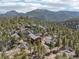 Expansive aerial view of the home, guesthouse, and scenic mountain views surrounded by towering trees and rock formations at 31911 Warrens Rd, Golden, CO 80403