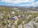 Aerial view of a home with solar panels and large metal outbuilding nestled in the forest at 31911 Warrens Rd, Golden, CO 80403