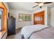Serene bedroom boasts a large window with wooded views, a dresser, and a wood-paneled closet at 31911 Warrens Rd, Golden, CO 80403