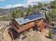 Stunning mountain home featuring a wraparound deck and solar panels, blending rustic charm with modern sustainability at 31911 Warrens Rd, Golden, CO 80403