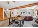Open concept living area with wood beam, modern furnishings, and a large television for entertainment and socializing at 31911 Warrens Rd, Golden, CO 80403