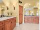 Bathroom showing dual sinks, tile flooring, wood cabinets and sconces at 1222 Buffalo Ridge Rd, Castle Pines, CO 80108