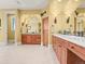 Spacious bathroom with double vanities, wooden cabinets, and arched mirrors at 1222 Buffalo Ridge Rd, Castle Pines, CO 80108