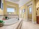 Relaxing bathroom features a soaking tub with tile surround and a large window above at 1222 Buffalo Ridge Rd, Castle Pines, CO 80108