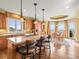Open kitchen with island, bar stools, granite counters, wood cabinets, and an adjacent dining area at 1222 Buffalo Ridge Rd, Castle Pines, CO 80108