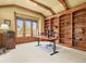 Home office with custom built-in shelving, a large window, and a traditional desk setup at 1222 Buffalo Ridge Rd, Castle Pines, CO 80108