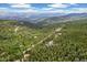 Stunning aerial view of a home nestled within a dense forest in a mountainous landscape at 1758 Sinton Rd, Evergreen, CO 80439