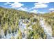 Stunning aerial view of mountain home nestled among trees with snow covered driveway at 1758 Sinton Rd, Evergreen, CO 80439