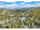 Aerial view of mountain home surrounded by lush green forests and snow-covered hills at 1758 Sinton Rd, Evergreen, CO 80439