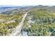 Scenic aerial view of the mountain home surrounded by lush forests and snow-covered mountains at 1758 Sinton Rd, Evergreen, CO 80439