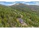 Beautiful home surrounded by lush green trees with a sloped landscape, perfect for privacy at 1758 Sinton Rd, Evergreen, CO 80439