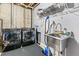 Basement laundry area with modern washer, dryer, utility sink, and concrete walls at 1758 Sinton Rd, Evergreen, CO 80439