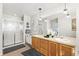 Bright bathroom with dual sinks, shower with glass doors, and plenty of towel storage at 1758 Sinton Rd, Evergreen, CO 80439