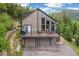 Mountain home featuring a spacious deck with a grill, seating, and a two-car garage at 1758 Sinton Rd, Evergreen, CO 80439