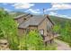 Mountain home features a deck, offering stunning views of the surrounding forest and hillside at 1758 Sinton Rd, Evergreen, CO 80439