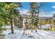 Mountain home exterior with wood siding surrounded by a snowy, treed landscape at 1758 Sinton Rd, Evergreen, CO 80439