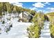 Exterior shot of mountain home surrounded by forest with snow-covered ground at 1758 Sinton Rd, Evergreen, CO 80439