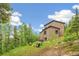 Serene backyard of a home featuring a hot tub and charming outdoor sitting area nestled in nature at 1758 Sinton Rd, Evergreen, CO 80439