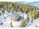Exterior shot of a lovely home nestled among snow-covered trees on a winter's day at 1758 Sinton Rd, Evergreen, CO 80439