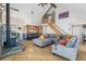 Open-concept living room with hardwood floors, wood burning stove and adjacent kitchen at 1758 Sinton Rd, Evergreen, CO 80439