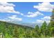 Breathtaking views of distant mountains and lush green trees from this mountain property at 1758 Sinton Rd, Evergreen, CO 80439