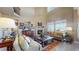 Bright living room featuring high ceilings, fireplace, large windows, and comfortable seating at 8605 S Zante Ct, Aurora, CO 80016