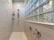 Modern shower with glass block window, tiled walls, and sleek fixtures at 8605 S Zante Ct, Aurora, CO 80016