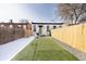 Cozy backyard featuring artificial turf, a private fence, and a detached house with a green front door at 1466 Knox Ct, Denver, CO 80204