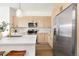 Bright kitchen with modern stainless appliances, light wood cabinets, and stone countertops at 1466 Knox Ct, Denver, CO 80204