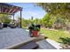 Well-maintained backyard featuring a stone patio, pergola, and manicured lawn with landscaping at 12189 Windy Trail Ln, Parker, CO 80138