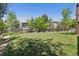Spacious backyard with a lovely green lawn, framed by a wooden fence and mature trees at 12189 Windy Trail Ln, Parker, CO 80138