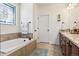 Bathroom featuring a soaking tub with tile surround, granite countertops, and a decorative stained glass window at 12189 Windy Trail Ln, Parker, CO 80138