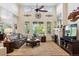 Bright living room with vaulted ceilings, large windows, fireplace, and comfortable seating at 12189 Windy Trail Ln, Parker, CO 80138