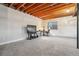 Unfinished basement with carpet, visible ceiling beams, white walls, and a window at 20201 Royal Troon Dr, Monument, CO 80132