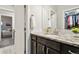 Bathroom vanity features granite countertop, dark wood cabinets, and views of bedroom and walk-in closet at 20201 Royal Troon Dr, Monument, CO 80132