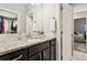 Bathroom vanity features granite countertop, dark wood cabinets, and views of bedroom and walk-in closet at 20201 Royal Troon Dr, Monument, CO 80132