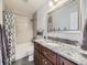 Well-maintained bathroom with a granite countertop vanity, a toilet, and a shower with gray subway tile at 9625 S Hackberry St, Highlands Ranch, CO 80129