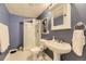 Bathroom with a corner shower, toilet, and pedestal sink featuring a framed mirror and cabinet at 9625 S Hackberry St, Highlands Ranch, CO 80129