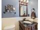 Chic bathroom featuring a granite vanity, stylish fixtures, and wainscoting at 9625 S Hackberry St, Highlands Ranch, CO 80129