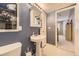 Cozy bathroom featuring a pedestal sink, a medicine cabinet, and a view into the next room at 9625 S Hackberry St, Highlands Ranch, CO 80129