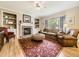 Cozy living room featuring a brick fireplace, built-in bookshelves, and plenty of natural light at 9625 S Hackberry St, Highlands Ranch, CO 80129