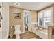 Bathroom featuring a soaking tub, natural light, and wood-look tile floor at 2496 S Leyden St, Denver, CO 80222