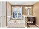 Bathroom featuring a soaking tub, single vanity, and large window with natural light at 2496 S Leyden St, Denver, CO 80222