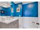 Bright bathroom with blue textured walls, white trim, and a modern vanity with a large mirror at 2496 S Leyden St, Denver, CO 80222