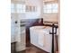 Close up of a bathtub featuring a white towel, wine glass and tub caddy, and natural light at 455 Forest St, Denver, CO 80220
