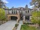 Elegant home with a stone archway garage, charming balconies, and manicured lawn at 455 Forest St, Denver, CO 80220